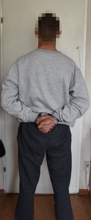 zatrzymany mężczyzna stojący tyłem do zdjęcia