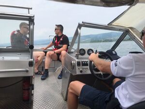 policjanci ze strażakami płyną łodzią