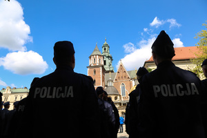Zdjęcie policjantów zza pleców przed nimi katedra