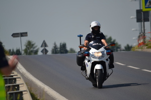 Policjant ruchu drogowego na motocyklu policyjnym porusza się po jezdni