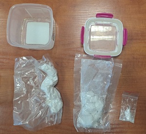 zabezpieczone narkotyki kryształki w plastikowym pojemniki oraz woreczki z białym proszkiem
