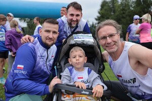 Pamiątkowe zdjęcie trzech uczestników i dziecka