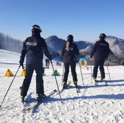 policjanci w patrolach narciarskich stoją na stoku