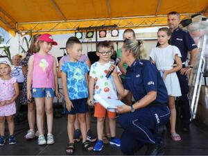 grupa dzieci w trakcie konkursu organizowanego przez umundurowaną policjantkę