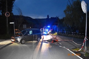 Miejsce wypadku, uszkodzony samochód marki Ford oraz rozbity motocykl a w tle radiowozy
