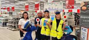 policjantka wraz z przedstawicielką Auchan oraz dziewczynami ubranymi w elementy umundurowania policyjnego na pamiątkowym zdjęciu