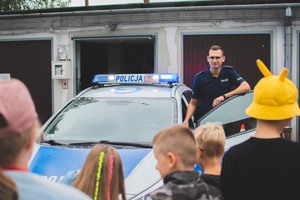 policjant prezentujący radiowóz