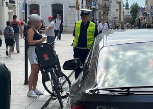 umundurowany policjant rozmawiający z rowerzystką w rejonie centrum miasta