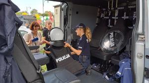 policjantka oddziału prewencji policji w radiowozie ubieram dziecko w strój policyjny