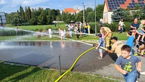 strażacy i dzieci leją wodę
