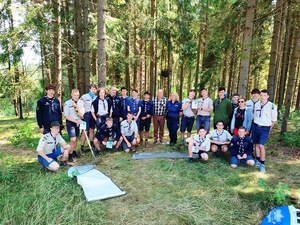 policjantka wraz z harcerzami na pamiątkowej fotografii w lesie