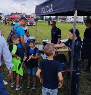 Rajsko piknik historyczno - wojskowy 3.09 (1)policjanci na stoisku przed którym stoi grupa dzieci