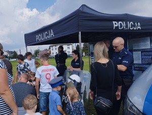 Rajsko piknik historyczno - wojskowy 3.09 (2) policjanci na stoisku przed którym stoi grupa dzieci obok fragment radiowozu