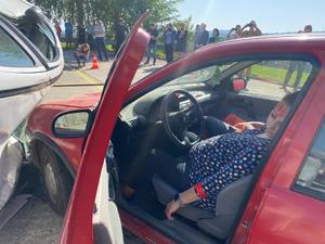 ranna nieprzytomna kobieta siedząca za kierownicą rozbitego samochodu