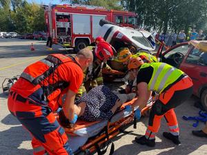 ratownicy i strażacy kładą na noszach poszkodawaną w wypadku kobietę