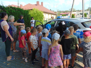 grupa przedszkolaków wraz z opiekunami oglądająca policyjny radiowóz