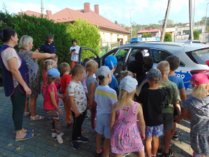 grupa przedszkolaków wraz z opiekunami oglądająca policyjny radiowóz