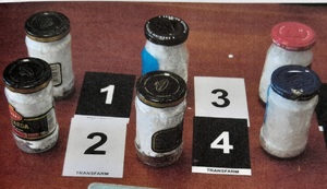 słoiczki z narkotykami obok znaczniki z numerami