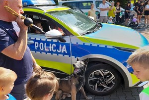 Przeciszów Policyjna Odyseja VI  (8) mężczyzna dzieci i pies obok radiowozu