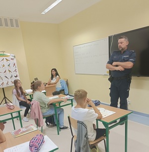 policjant rozmawia uczniami w klasie