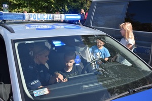 dzieci oglądające radiowóz w towarzystwie policjantki