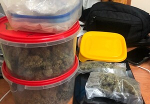 zabezpieczone narkotyki w plastikowych pudełkach i workach foliowych. Na zdjęciu widać też tablet, telefon oraz torebkę typu nerka