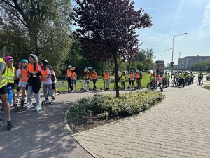 dzieci i policjanci w oczekiwaniu na sygnał zielony przy przejeździe dla rowerów