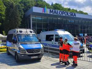 Radiowóz OPP w Krakowie, obok stoją ratownicy medyczni