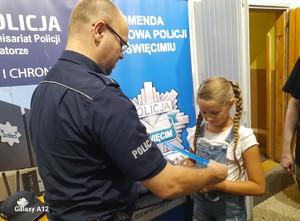 policjant zakłada opaskę dziewczynce