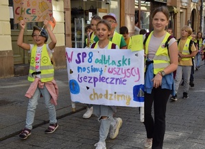 dziec w marszu dziewczynka niesie transparent z napisem w sp8 odblaski nosimy wszyscy i bezpiecznie chodzimy