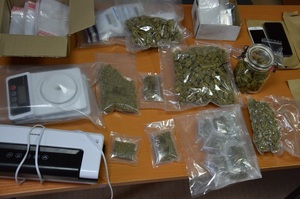 worki foliowe z zawartością suszu roślinnego, zgrzewarka foliowa, waga elektorniczna oraz telefony komórkowe znajdujące się na stole