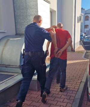 Zatrzymany doprowadzany do radiowozu