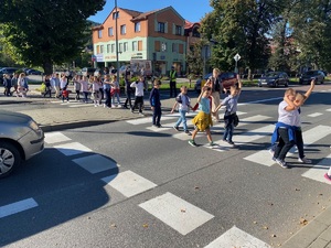 dzieci przechodzące przez drogę na oznakowanym przejściu dla pieszych