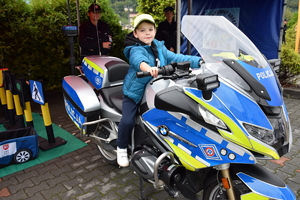 dziecko siedzące na policyjnym motorze