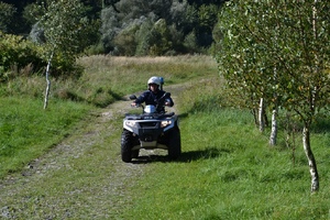 Policjant jadący służbowym quadem.