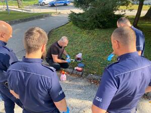 grupa policjantów przyglądająca się pokazowi tamowania krwotoku
