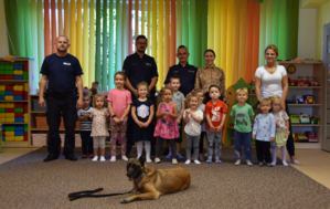 Zdjęcie grupowe. Policjanci, pies służbowy, wychowawcy oraz dzieci z przedszkola