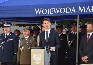 Przemawia Wicewojewoda Małopolski w tle zgromadzeni na uroczystości w tym zastępca Komendanta Wojewódzkiego Policji inspektor Piotr Morajko oraz Komendant Miejski Policji w Krakowie inspektor Zbigniew Nowak