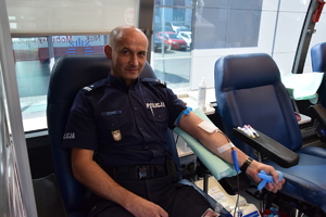 umundurowany policjant podczas oddawania krwi  w krwiobusie