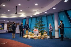 przedstawiciele KPP wreczają prezenty delagacji DPS przy choince w sali konferencyjnej KPP w Gorlicach