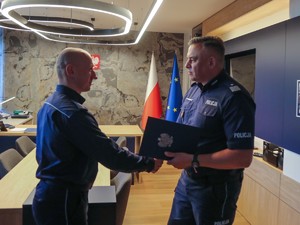 Komendant Wojewódzki wręcza list gratulacyjny jednemu z policjantów