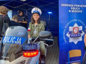 dziewczynka w policyjnej czapce siedząca na motocyklu
