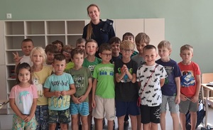 wspólne zdjęcie policjantki z dziećmi w klasie lekcyjnej