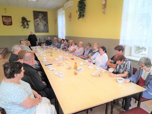 spotkanie z seniorami Monowice radny, dzielnicowy i  seniorzy przy stole