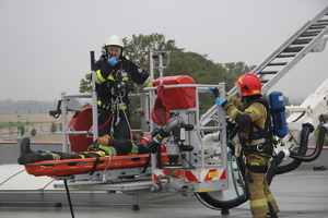 strażacy przy pomocy podnośnika ewakuują pracownika z dac