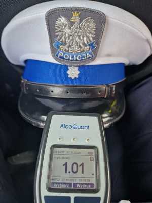Policyjna czapka ruchu drogowego oraz alkomat wskazujący zawartość alkoholu