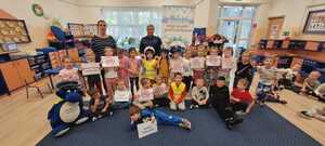 grupa przdszkolaków na pamiątkowym zdjęciu z policjantką oraz Inspektorem Wawelkiem