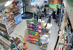 Dwóch agresywnych mężczyzn stoi przy ladzie w sklepie. Z drugiej strony sprzedawca