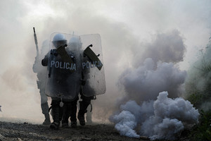 policjanci idą pod osłoną dymu