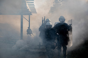 policjanci wybiegający z dymu